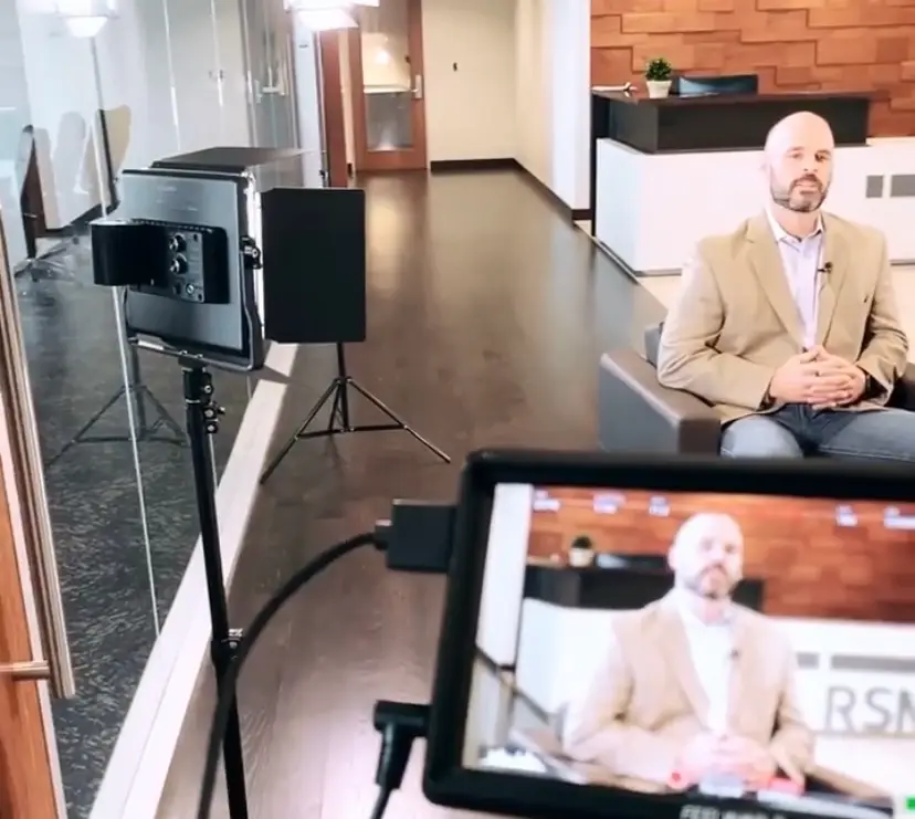 Man sitting down during a video shoot for SEO.